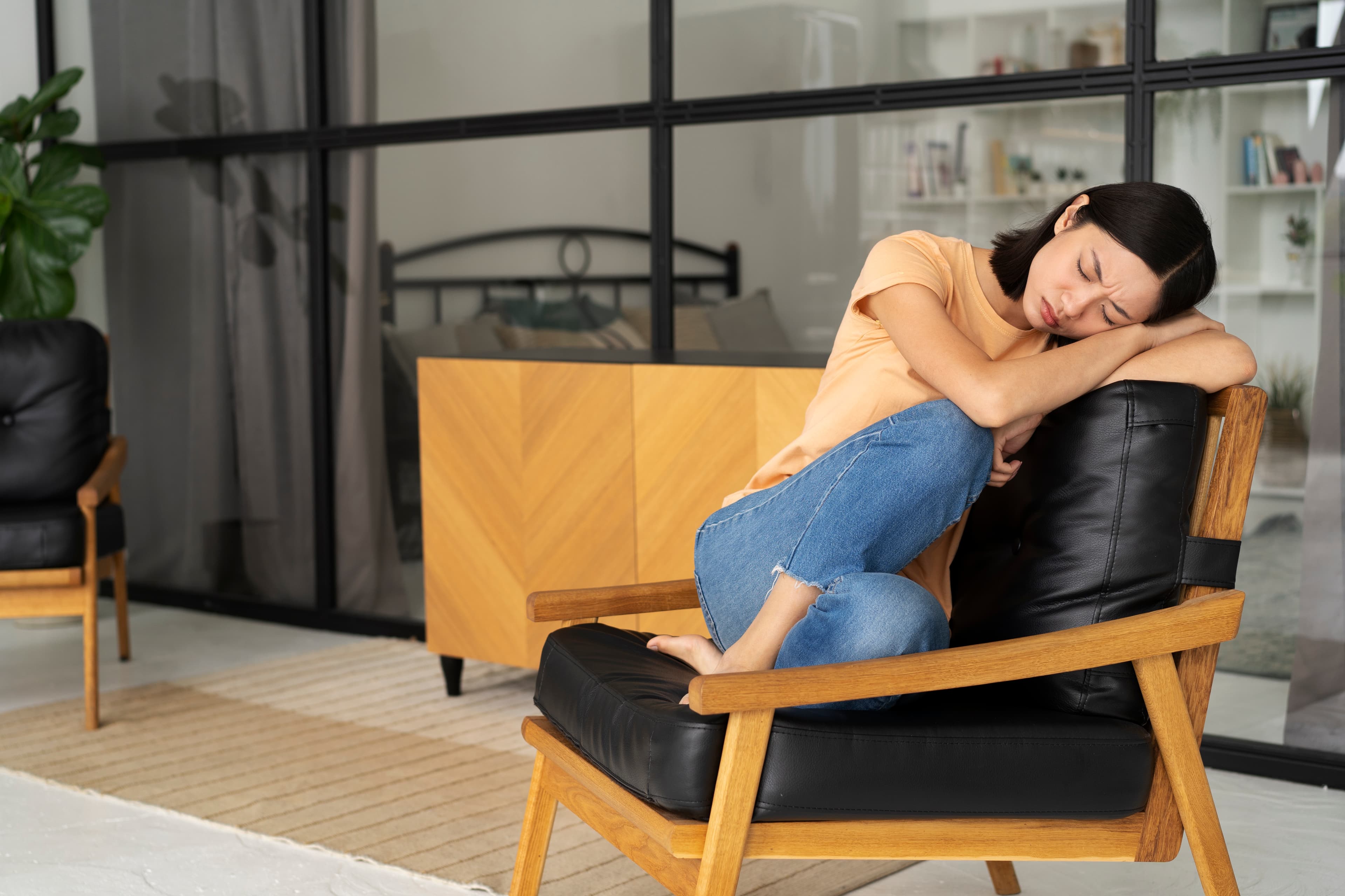 A person feeling sad and exhausted on the couch and looking to get started with therapy in Singapore.