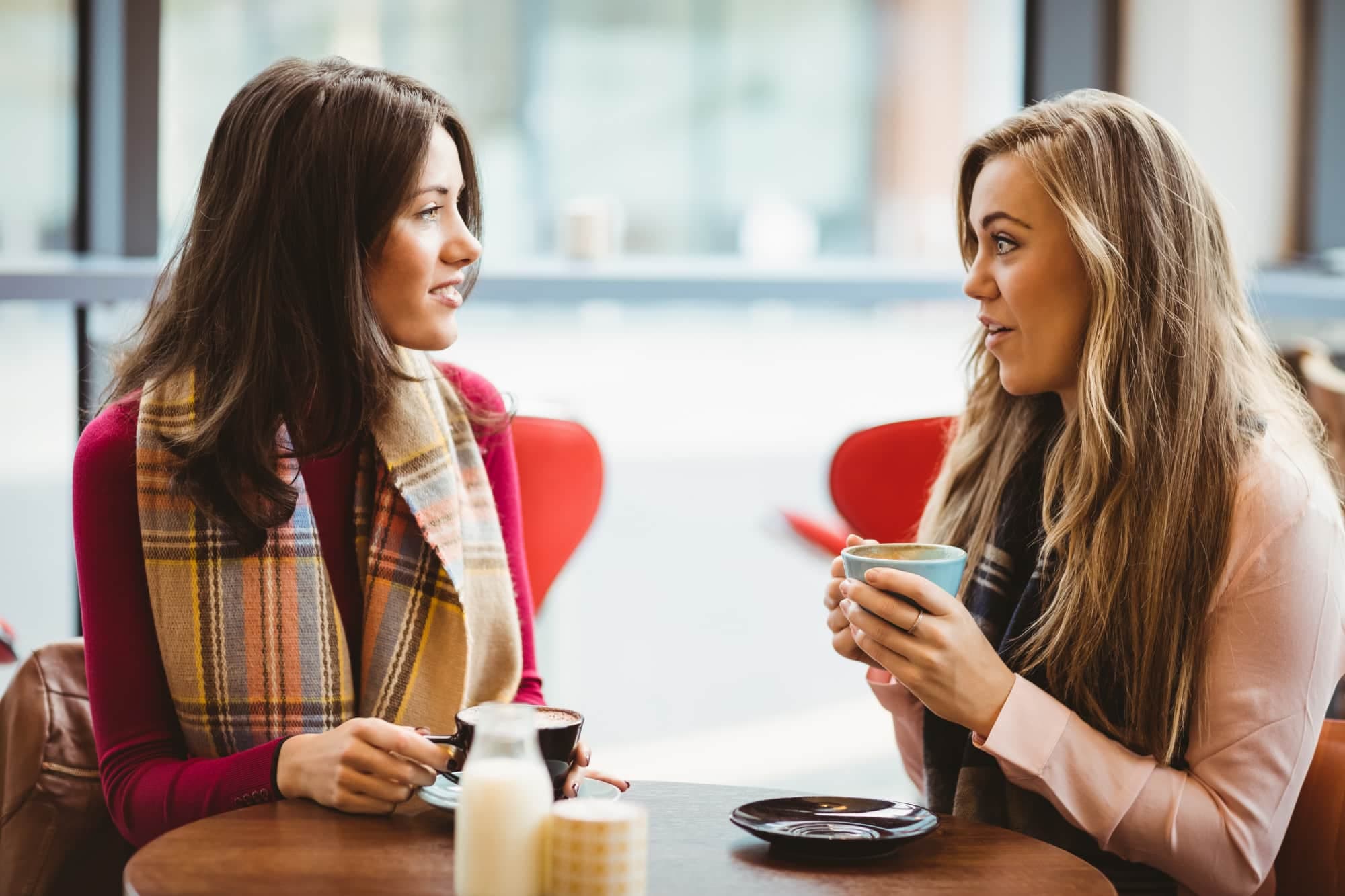 Friends talking to each other in a cafe about online counselling.