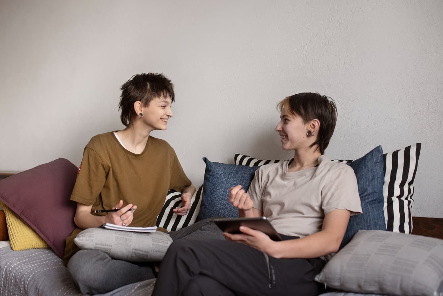 A couple sitting on the coach and discussing wether to seek relationship counselling.