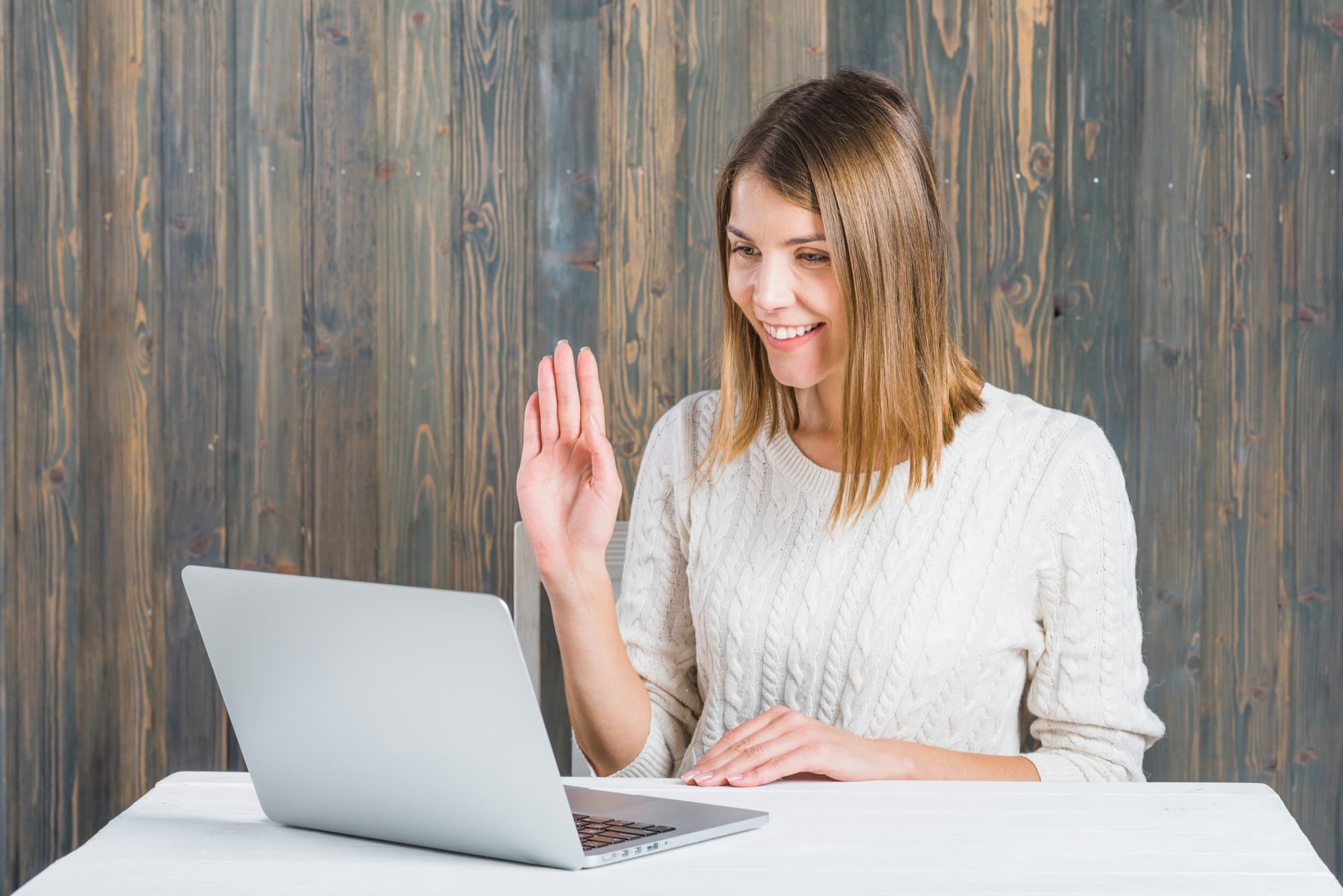 A person greeting their online therapist with a smile at the beginning of a therapy session.