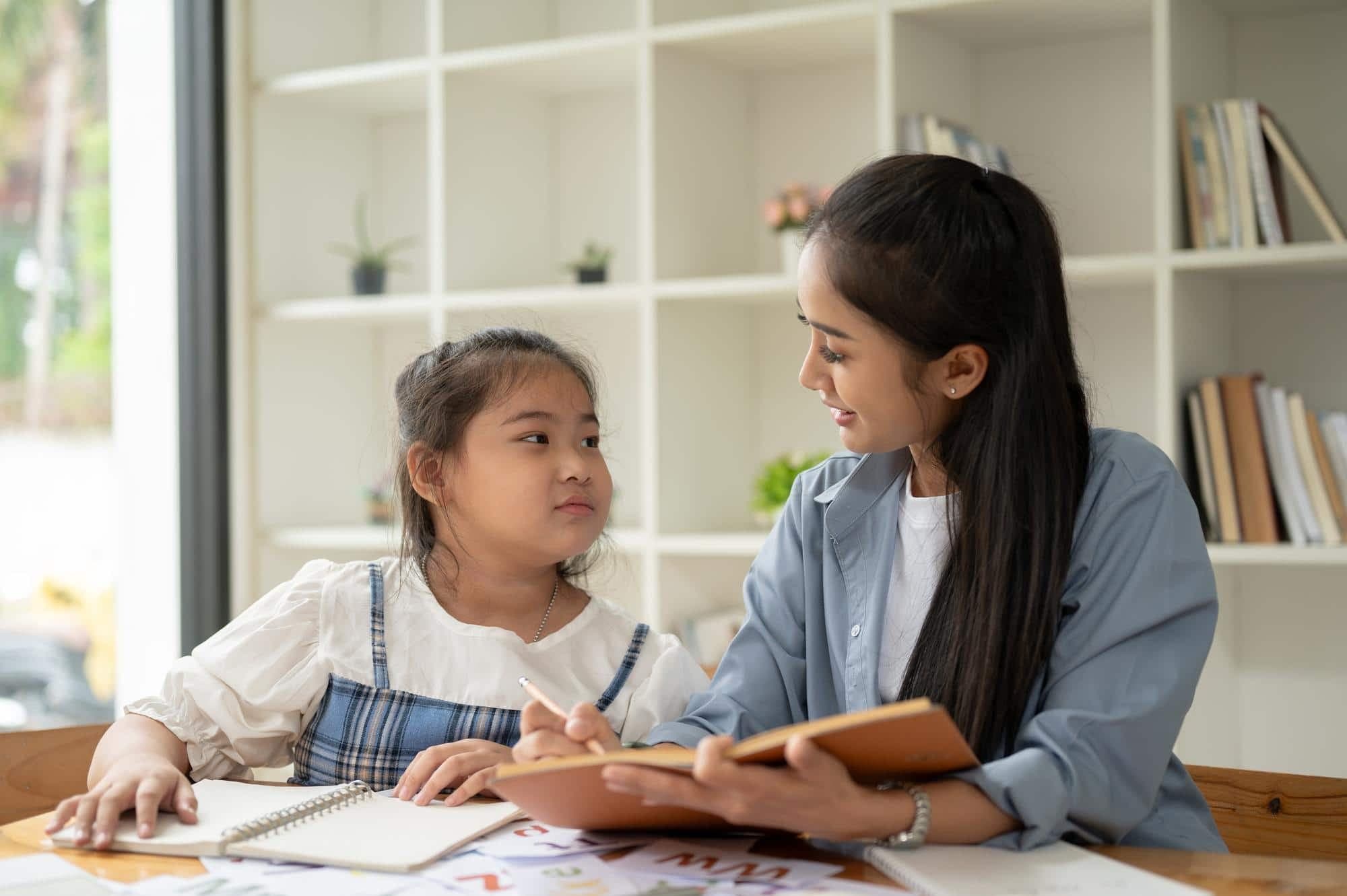 A young Asian girl engaging in a therapy session with a child psychologist in Singapore.