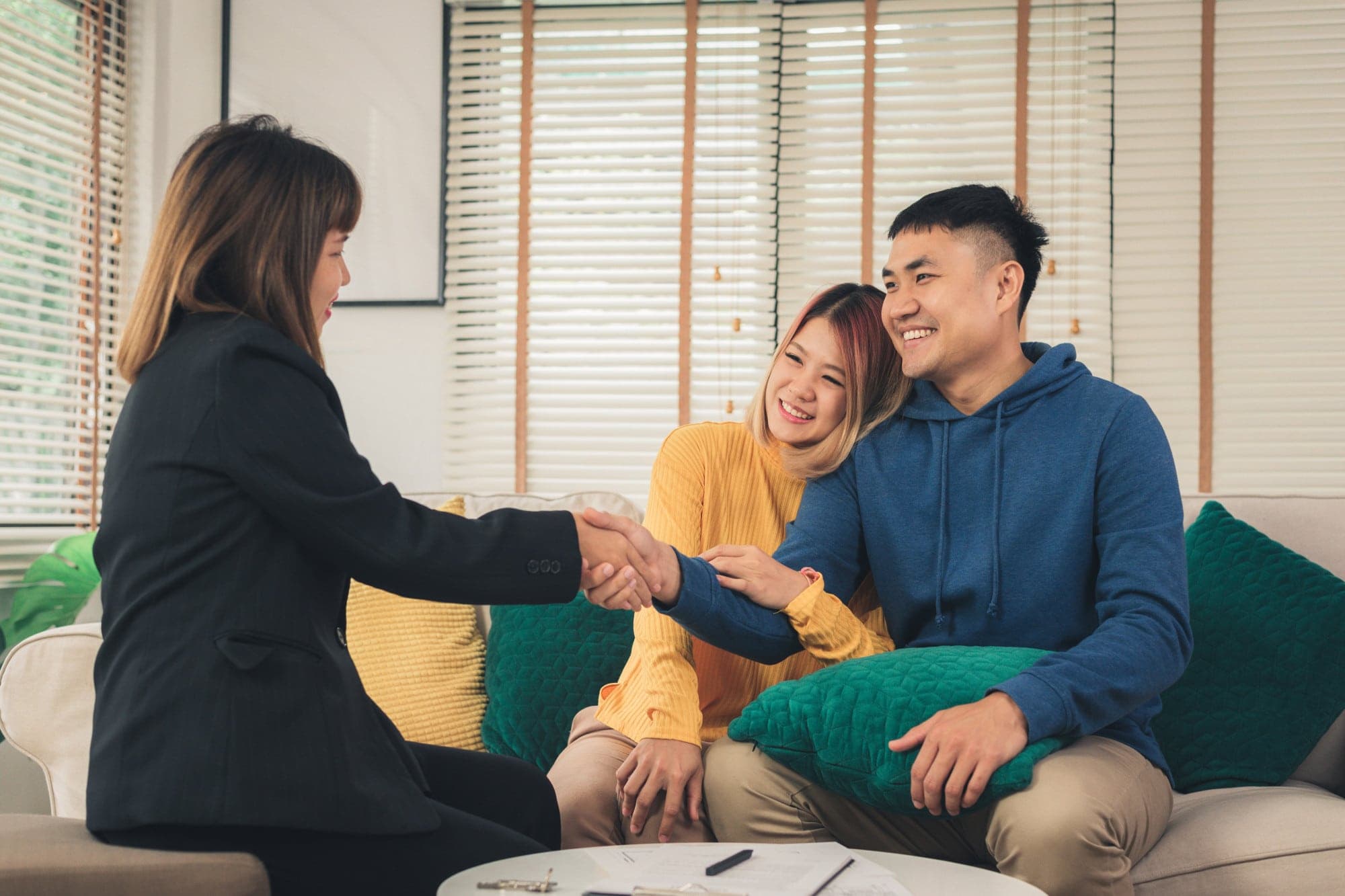 A couple looking happy and smiling at the therapist during a marriage counselling session.