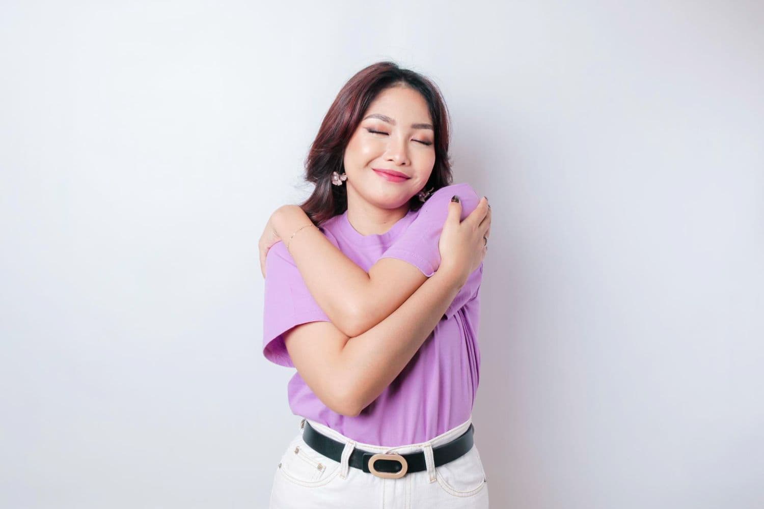 A person hugging themselves after reading a mental health quote about self-love.