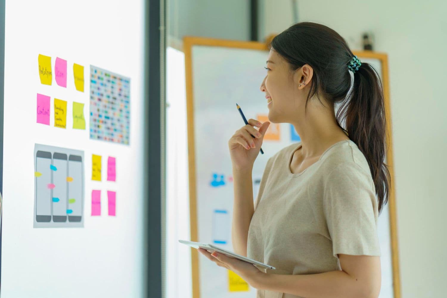 A person planning their life goals, considers therapy for personal growth. Several sticky notes with notes on them are visible on a wall.