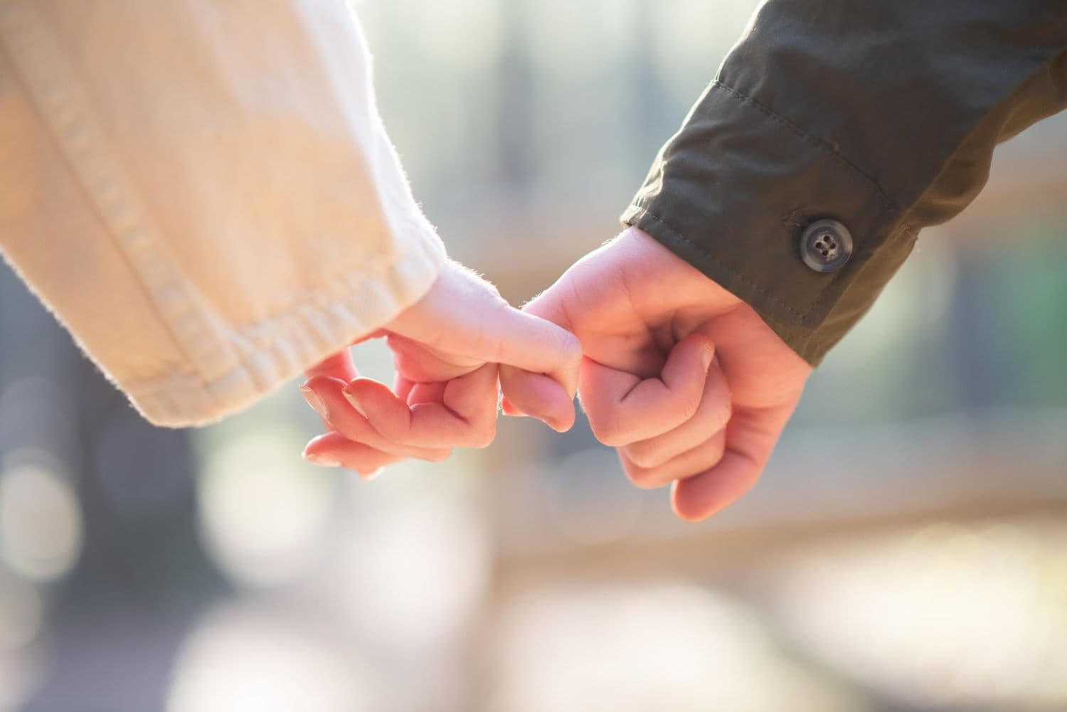 A picture of two people's hands with their pinky fingers linked. This blog explores different bases in a relationship.