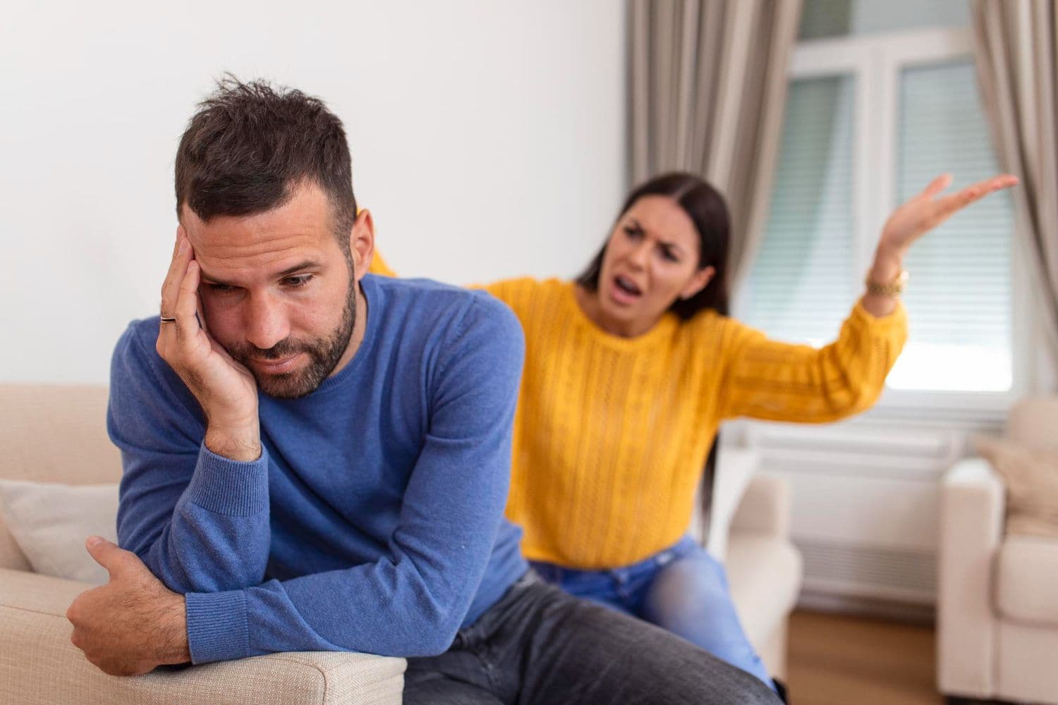 A wife yelling at her husband in the living room.