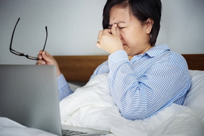 An employee struggling with the stages of burnout at home.