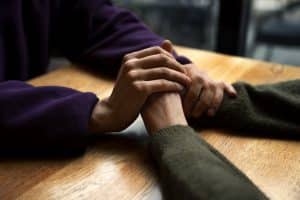 Hands holding each other for mental health support in Singapore.