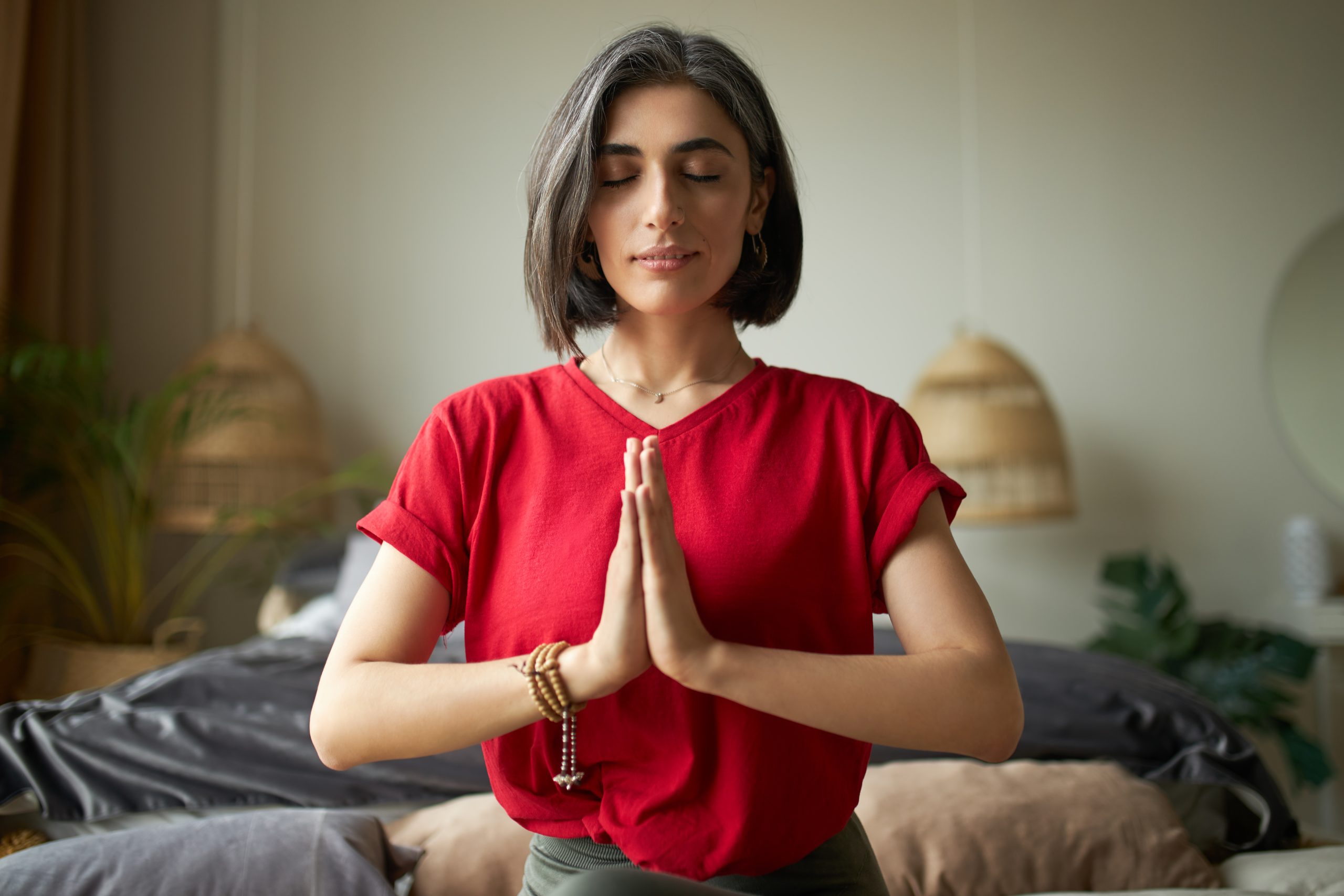A person holds the Namaste pose and meditates, embodying the practice of what therapy is.