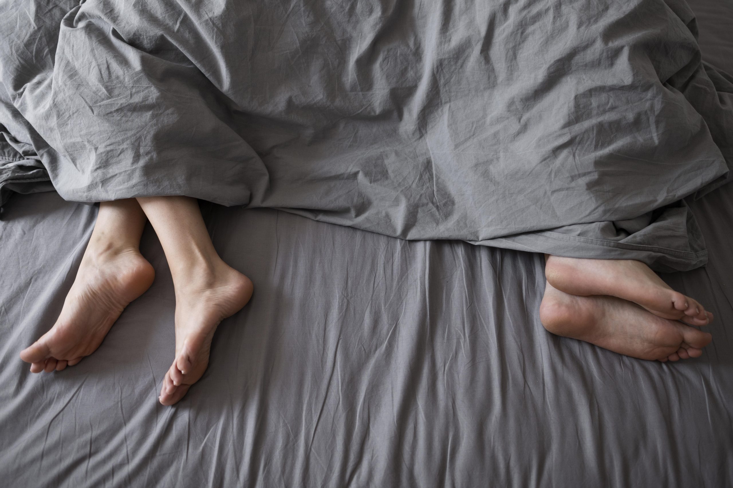 Couple sleeping far away from each other due to sex-related issues. Marriage counselling can help.