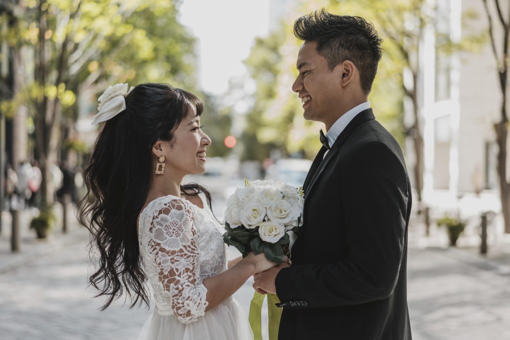 Bride and groom posing in the street with a flower after gaining the benefits of marriage counselling in Singapore.