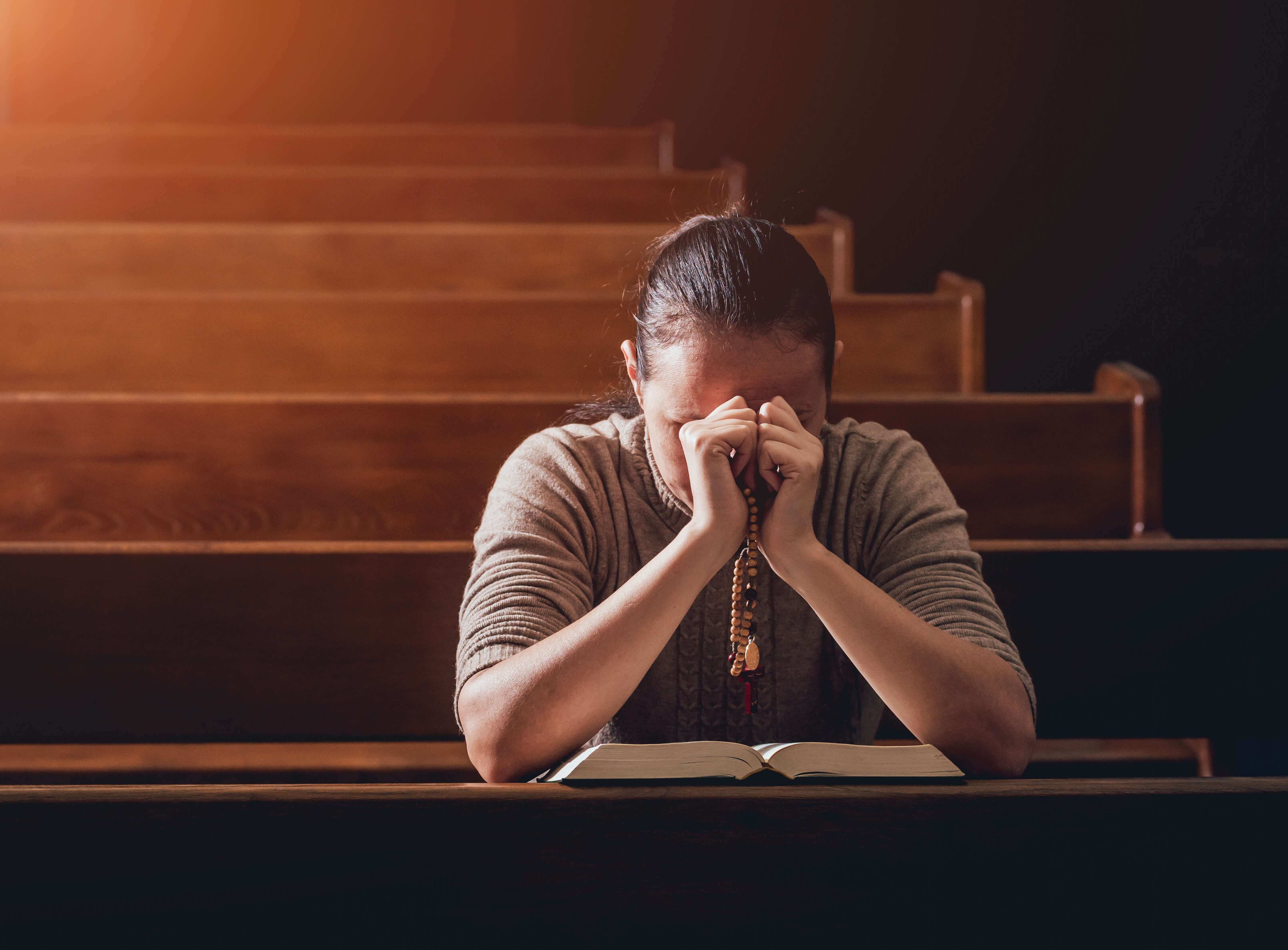 Person praying while going through a stage of grief during grief counselling in Singapore.