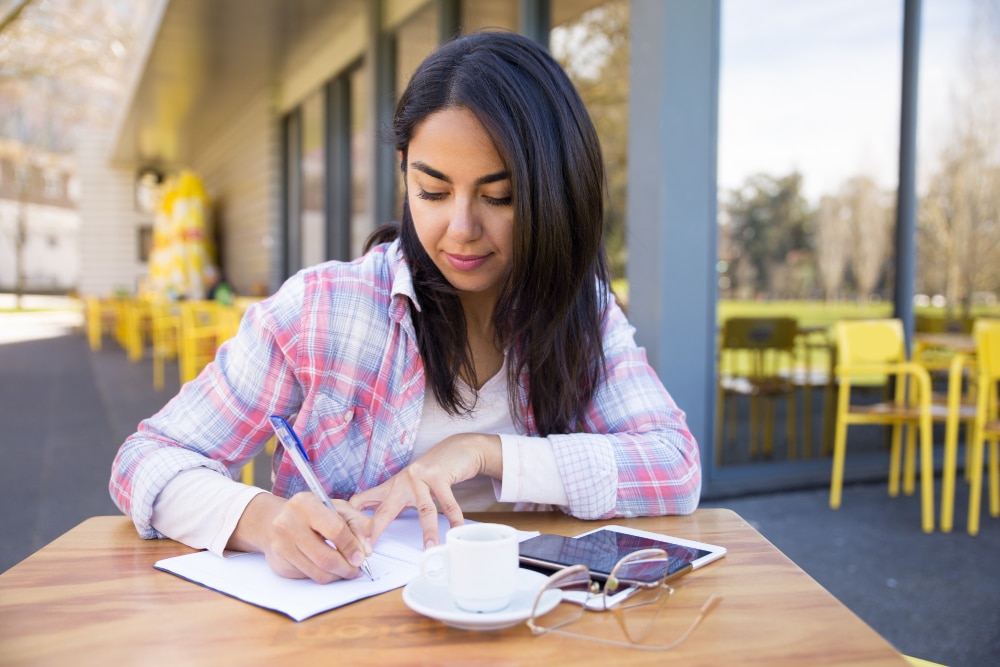 A person journalling and following self-care therapeutic tools.