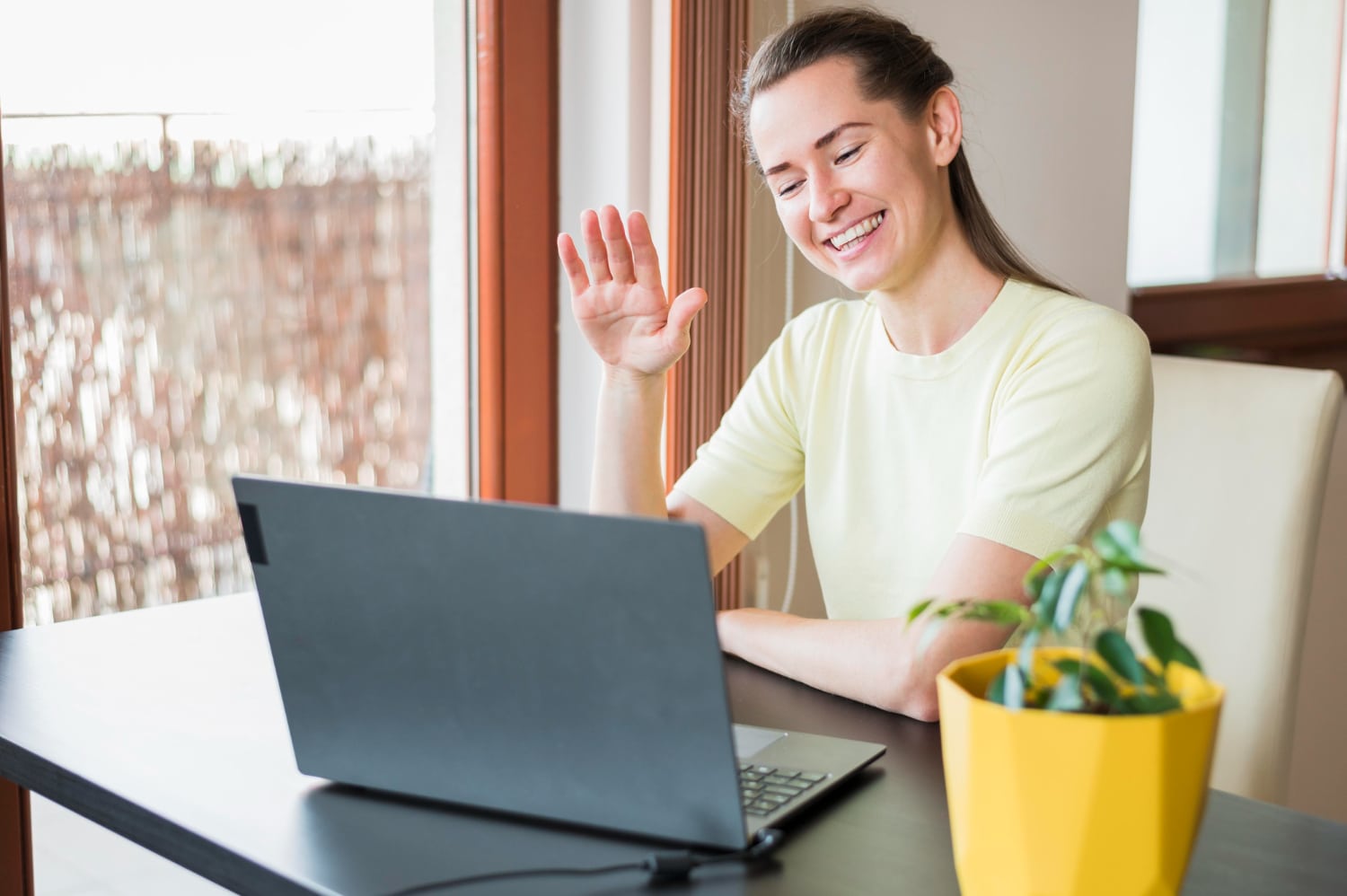 An online therapist in Australia waving hi to a client during therapy.