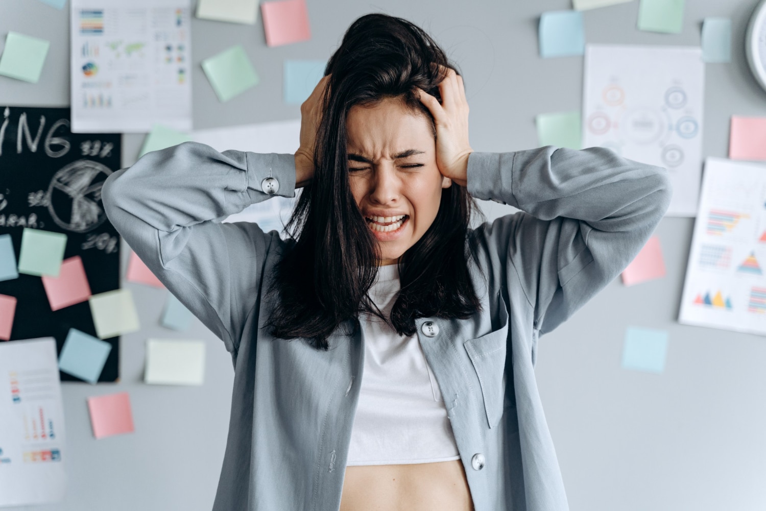 A person holding their head, looking distressed while struggling with emotions.