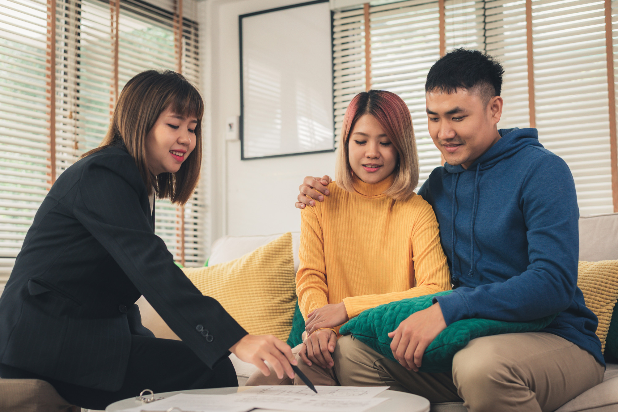A couple talking to a therapist during an in-person couples therapy session.