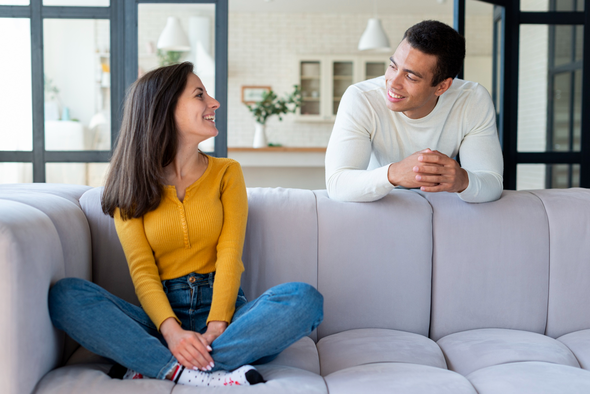 A couple sitting on the couch and preparing to attend a premarital counselling session before their marriage.