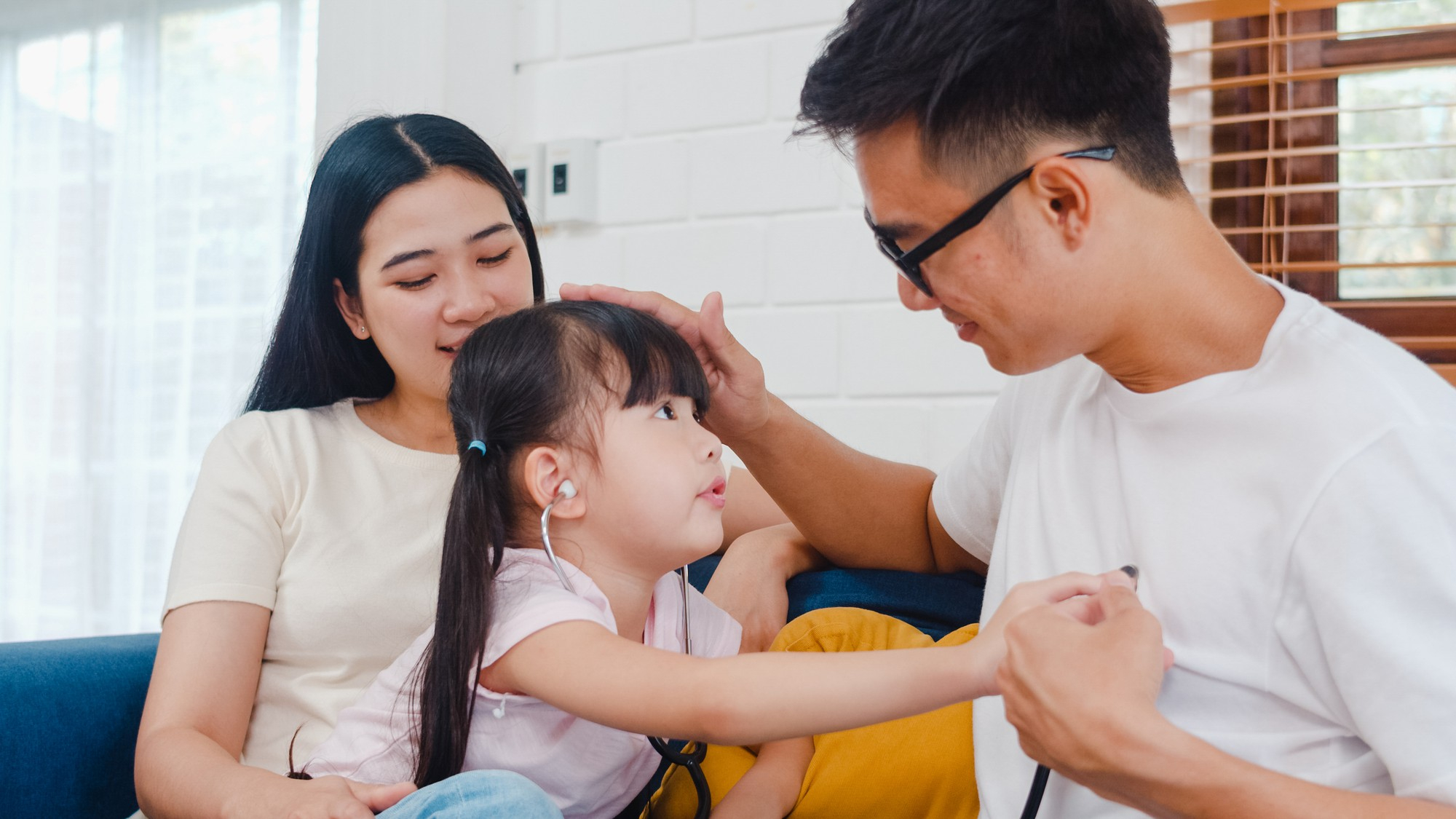 Parents and a child sitting on the coach and applying therapeutic skills learned during premarital counselling in Singapore.