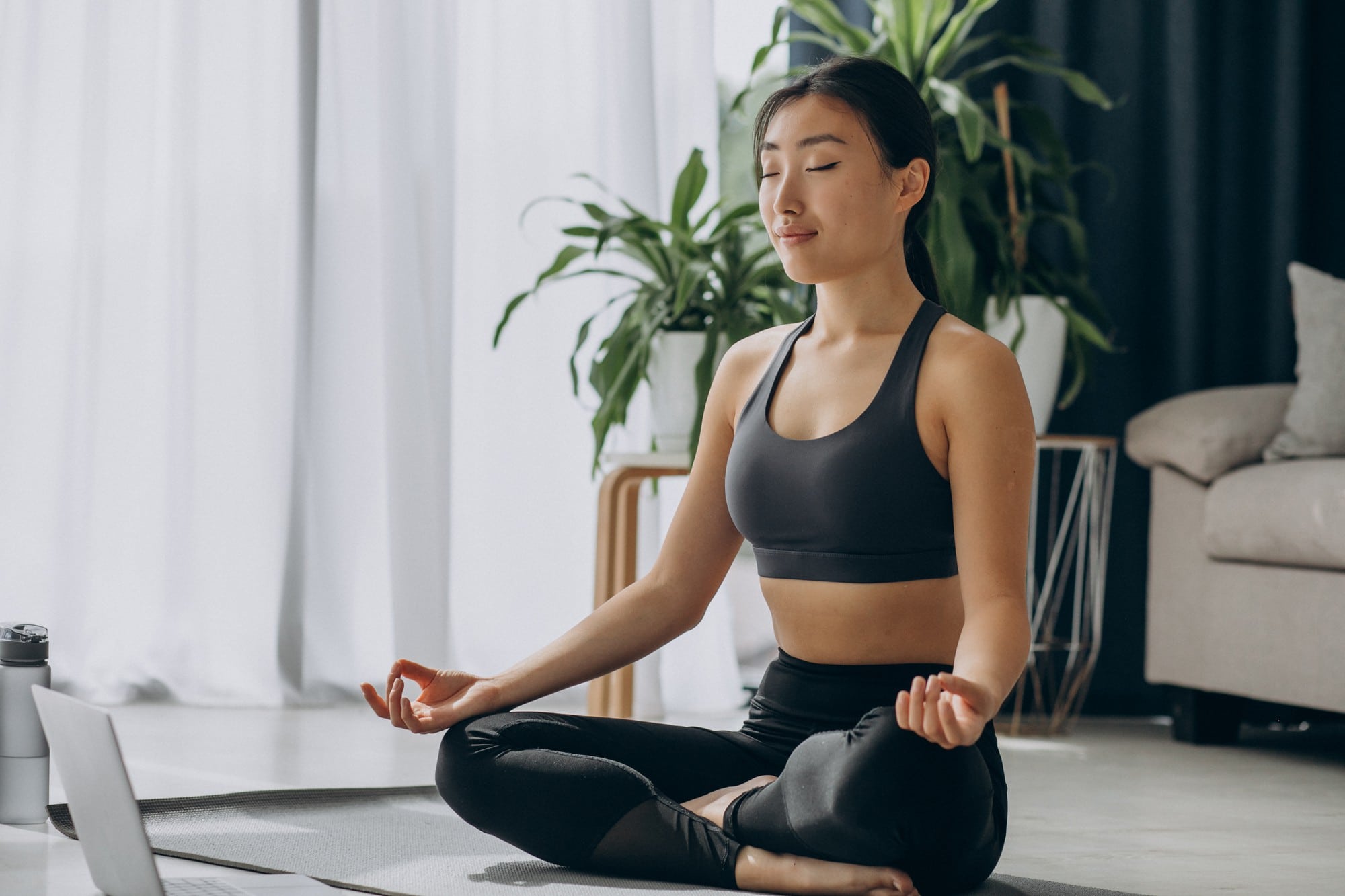 A Singaporean woman practising mindfulness breathing during an online counselling session.