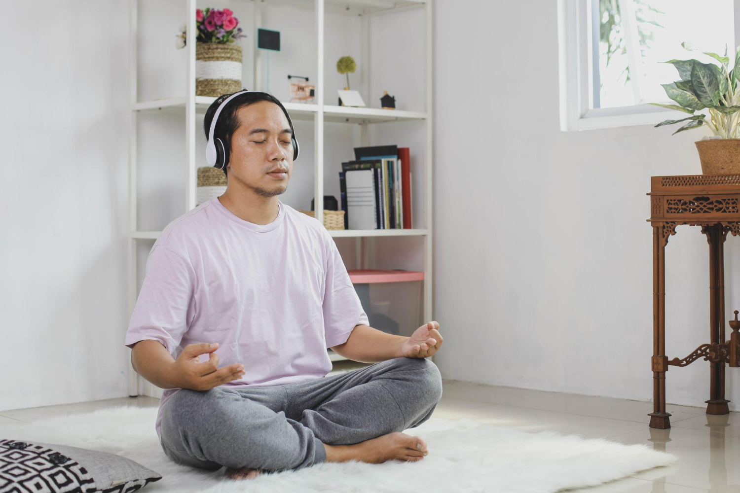 Asain man using meditation skills learnt in therapy to manage anxiety symptoms.