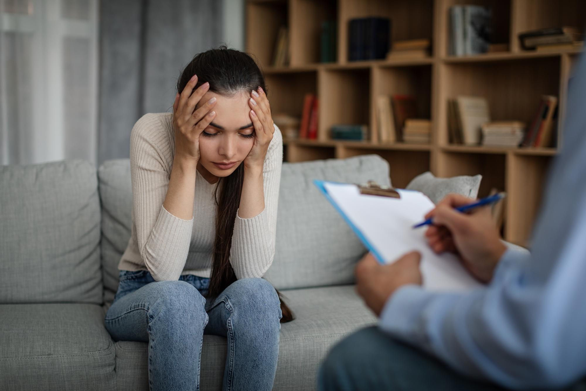 A person feeling overwhelmed during a session with a therapist in Singapore.